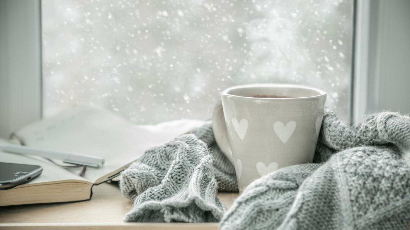 Une tasse de thé bien chaude au bord d'une fenêtre en plein hiver